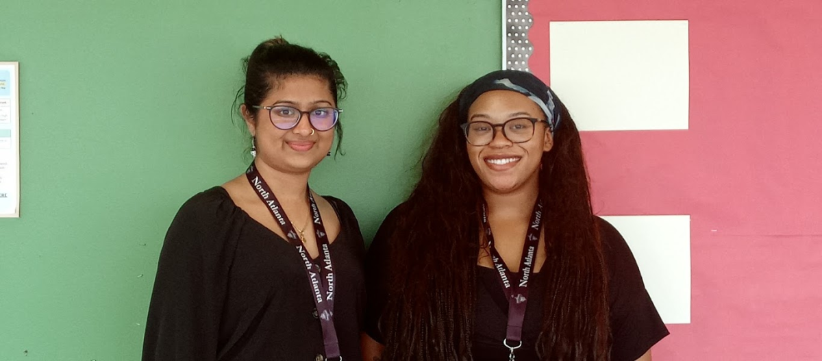 The New Year's Here: Advisors Diya Kamath and India Jeffries smiling outside of their office ready to help students!