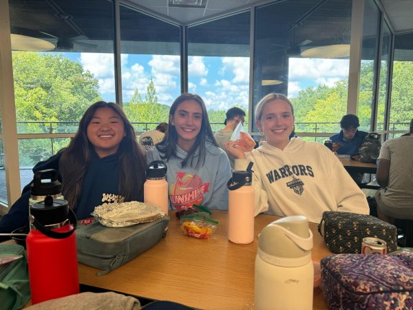 Lunch is no time for messing around: Juniors Michelle Baek, Samantha Bailey, and Kate Saxon enjoying their lunch in the chaotic cafeteria.