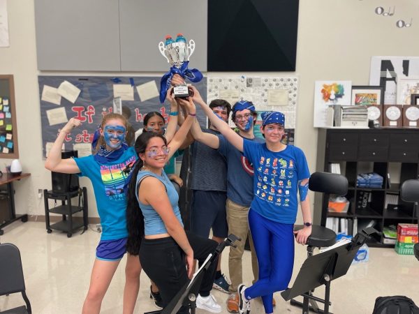 True Blue Triumph: NAHS orchestra champions raise their trophy in celebration.
