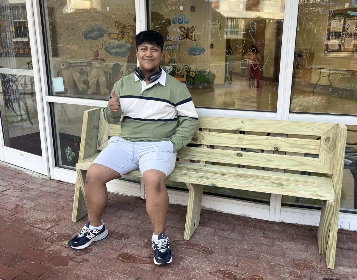 Sophomore Jessie Rojas at his former elementary school, E. Rivers, sitting on the bench he built for the MYP Project.