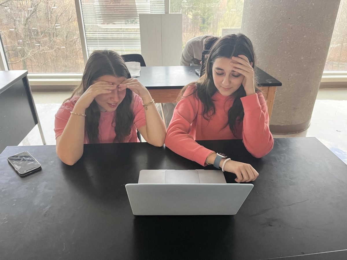 Juniors Maggie Hunter and Elizabeth Greer anxiously watch the time as they try to complete their assignments at the last possible moment.